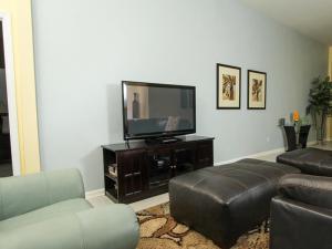 a living room with a flat screen tv and leather furniture at Comrow Villa 7739 in Orlando