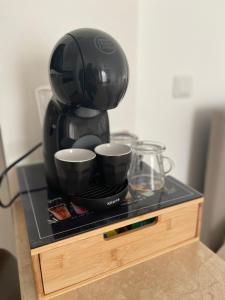 a coffee maker sitting on a counter with two cups at Logement très chaleureux à Marseille in Marseille