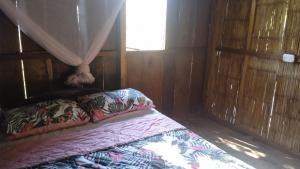 montecristo hostel في سانتا مارتا: سرير في غرفة خشبية مع نافذة
