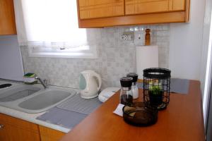 a kitchen with a sink and a counter top with a sink at Small farmhouse by M in Egina +22 photos