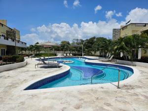 a swimming pool in a resort with trees and buildings at Las Palmas Joliet in Roatan
