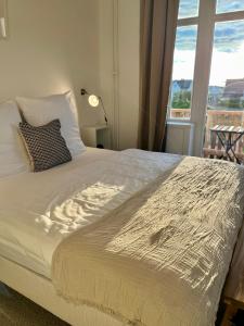 Schlafzimmer mit einem großen Bett und einem Fenster in der Unterkunft Hotel Villa Klasen in Wenningstedt-Braderup