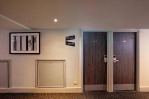 un pasillo con dos puertas y letreros en la pared en President Hotel, en Londres