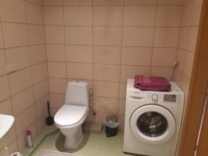 a bathroom with a toilet and a washing machine at Vita apartment in Vilnius