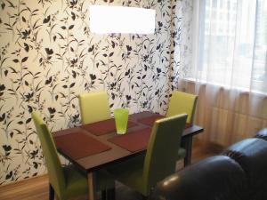 a dining room with a table and chairs and a table at Vita apartment in Vilnius