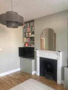 a living room with a fireplace and a mirror at Lovely 1-bedroom flat in Wimbledon in London