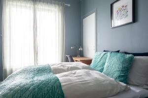 um quarto com uma cama com paredes azuis e uma janela em Kollen Slottet em Oslo