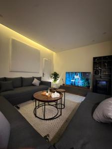 a living room with a couch and a tv at شقة في حي المغرزات in Riyadh