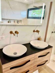 Baño con 2 lavabos en una encimera negra en Villa contemporaine avec piscine, en Bidart