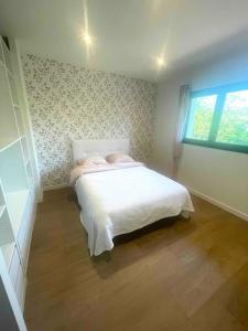 1 dormitorio con cama y ventana. en Villa contemporaine avec piscine, en Bidart