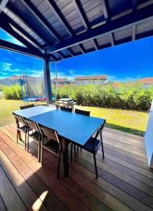 una mesa azul y sillas en una terraza de madera en Villa contemporaine avec piscine, en Bidart
