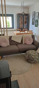 sala de estar con sofá marrón con almohadas rosas en Cim's Apartments Cerdanya 2, en Bellver de Cerdanya 