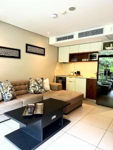a living room with a couch and a kitchen at Resort Retreat, Private Suite, Zimbali Estate in Ballito