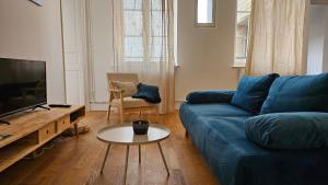 sala de estar con sofá azul y mesa en T3 Duplex - Vue sur toits & Cité en Carcasona