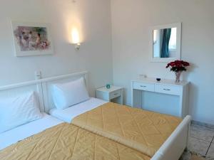 a white bedroom with two beds and a mirror at Apartments MARGARITA Kaizer Bridge in Achílleion