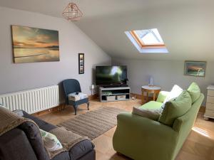 een woonkamer met een bank en een tv bij Studio 11 in Ballymoney
