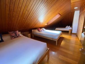 um quarto com 2 camas e um tecto de madeira em La Casa de Enzo em Argoños