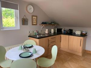 een keuken met een witte tafel en stoelen en een aanrecht bij Studio 11 in Ballymoney