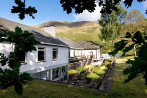 a house with a patio with chairs and umbrellas at YHA Patterdale in Glenridding