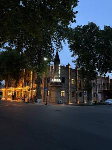 un bâtiment avec une tour d'horloge sur le côté d'une rue dans l'établissement Arba Hotel, à Samarcande