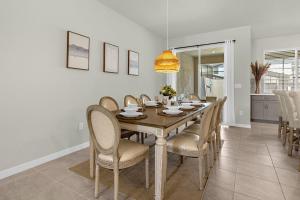 4BR Home w Full Resort Access - Near Disney في كيسيمي: غرفة طعام بها طاولة وكراسي