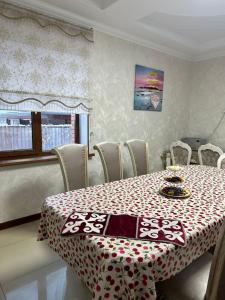 ein Esszimmer mit einem roten und weißen Tisch und Stühlen in der Unterkunft 阿拉木图陶萨马勒民宿 in Almaty