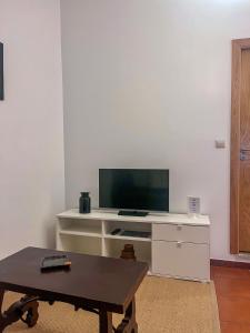 ein Wohnzimmer mit einem TV auf einem weißen Schreibtisch in der Unterkunft Imperial Douro Apartamento 2 in Peso da Régua