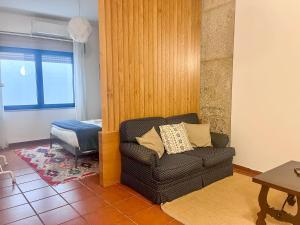 a living room with a chair and a bedroom at Imperial Douro Apartamento 2 in Peso da Régua
