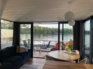 a living room with a couch and a table at Modernes festliegendes Hausboot mit großzügiger Dachterrasse und Ruderboot in Röbel