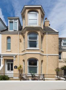 Una gran casa de ladrillo con ventanas en una calle en Eden House & Aquila House - Beach Apartments & Suites, en Saint Helier Jersey