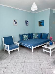 un divano blu e una sedia in soggiorno di Zoel's House in Chalkidiki ad Ayía Paraskeví