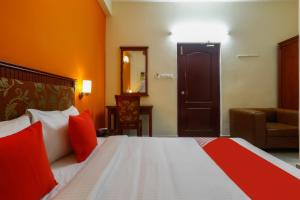 清奈的住宿－Collection O Mamieyaar Veedu，配有红色枕头的床的酒店客房