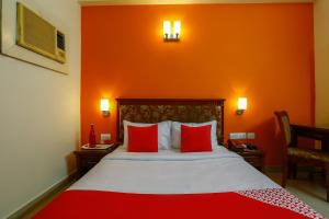 a hotel room with a bed with red walls at Collection O Mamieyaar Veedu in Chennai