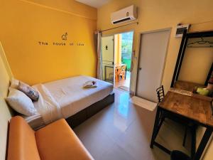 Habitación con cama, sofá y espejo. en ลิตเติ้ลโฮม ที่พักเพชรบุรี en Phetchaburi