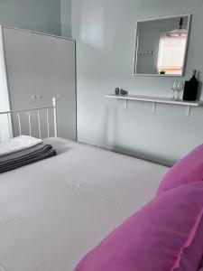 biała sypialnia z łóżkiem i lustrem w obiekcie Zoel's House in Chalkidiki w mieście Ajia Paraskiewi