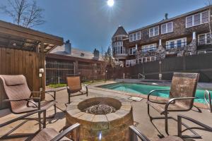a patio with chairs and a fire pit next to a pool at Luxury Condo Steps to Park City Mountain Resort! Heated Pool & Hot Tub -Snowblaze 309 in Park City