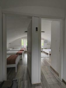 a living room with two beds and a room with a hallway at Holiday Home Casa Rondo in Bihać