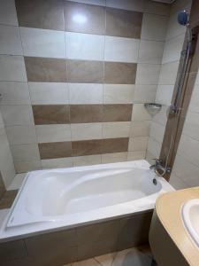 a white bath tub in a bathroom with a sink at Dubai Entire Serviced Room Unit Excellence in Dubai