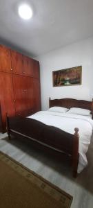 ein Schlafzimmer mit einem großen Bett und Holzschränken in der Unterkunft Fjori's Apartment in Korçë