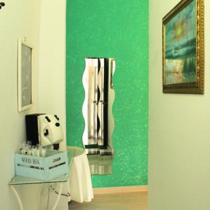 um quarto com uma parede verde e uma mesa com uma máquina em Maya guest house em Vietri
