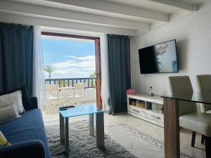 プラヤ・デ・ラス・アメリカスにあるPARQUE SANTIAGO 2, Playa de Las Americasのリビングルーム(ソファ、テレビ、バルコニー付)