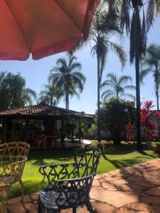 un patio con 2 sillas y una sombrilla en Lazer e descaso familiar, en Senador Canedo