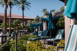 eine Reihe von Stühlen mit Sonnenschirmen und Palmen in der Unterkunft The Westin Lake Las Vegas Resort & Spa in Las Vegas