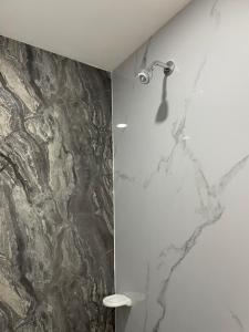 a shower in a bathroom with a marble wall at Ancestral Casa de Campo in Roldanillo