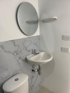 a bathroom with a sink and a mirror and a toilet at Ancestral Casa de Campo in Roldanillo