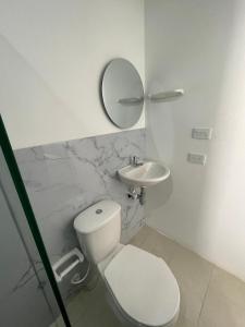 a white bathroom with a toilet and a sink at Ancestral Casa de Campo in Roldanillo