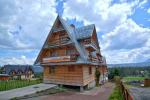 una casa de madera con techo de gambrel en Ośrodek Wczasowy U Góralki en Murzasichle