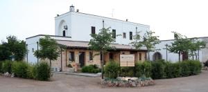 un gran edificio blanco con un cartel delante en Masseria La Duchessa, en Veglie