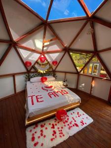 um quarto com uma cama numa tenda com rosas vermelhas em Domos de Glamping con Jacuzzi y Piscina en San Rafael Frente al charco la Cristalina em San Rafael
