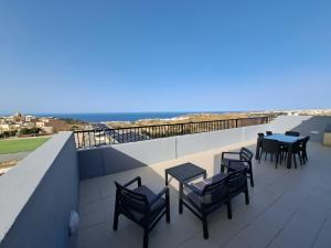 une rangée de tables et de chaises sur un toit dans l'établissement Sea view penthouse, à Żebbuġ